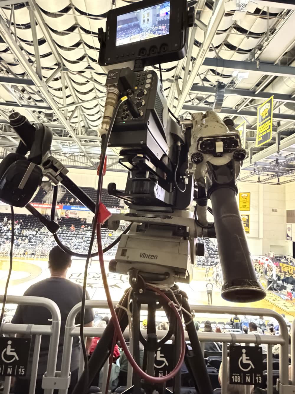 Production camera over a basketball court with the keeper beneath the camera head